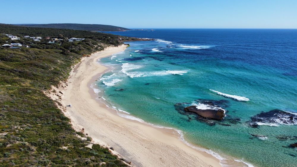 Aerial view of turquoise Caribbean water along a sandy shore